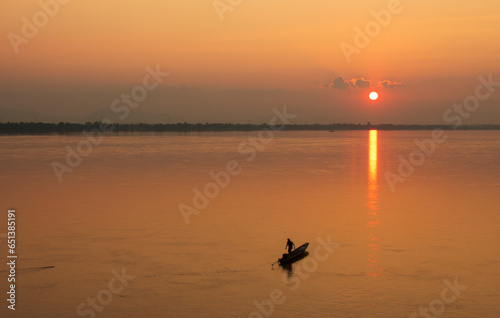 View of the Mekong River with boats and fishermen During sunset around Pakse City, Champasak Province, Laos photo