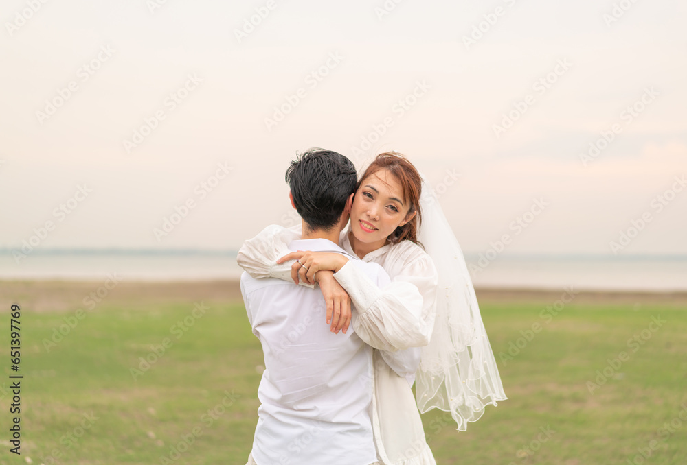 Happy young Asian couple in bride and groom clothing Happy young Asian couple in bride and groom clothing