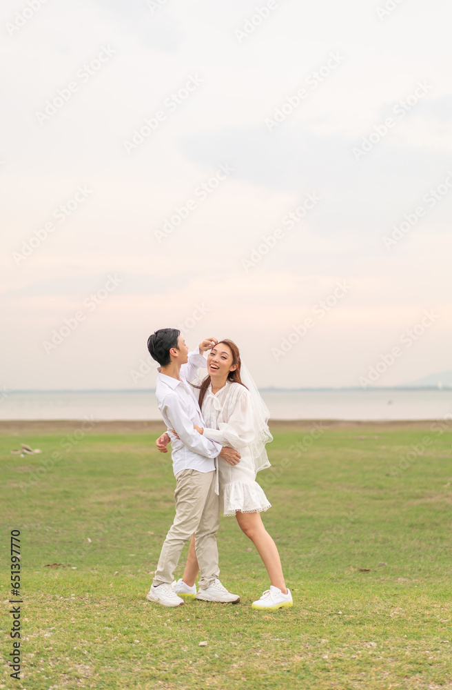Happy young Asian couple in bride and groom clothing Happy young Asian couple in bride and groom clothing