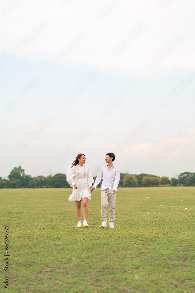 Obraz premium Happy young Asian couple in bride and groom clothing