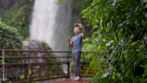 Man Creating Vlog Content Beside Waterfalls