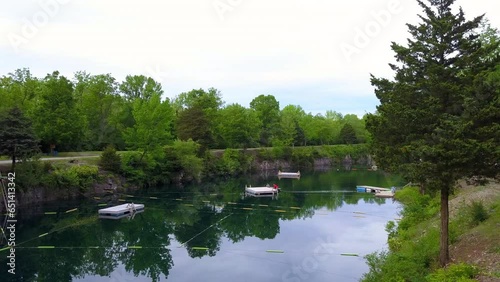 Panning Shot Of People Standing On Floating Platform Over Pond Near Trees And Plants Against Sky - Crawfordsville, Indiana photo