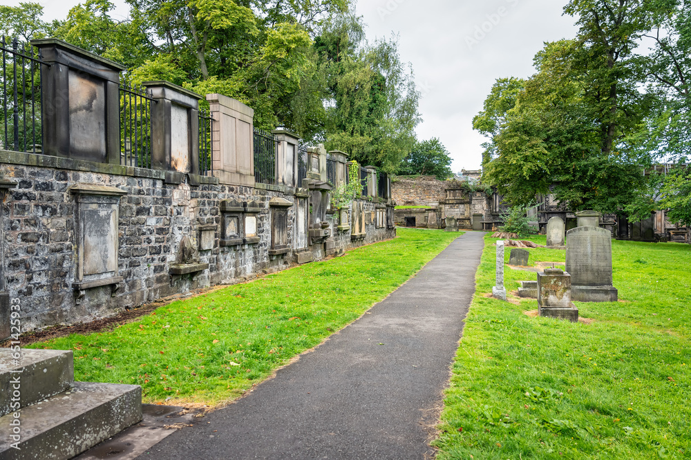 Very old graves located next to dwellings in Greyfriars Cemetery in Edinburgh, Scotland. Very old graves located next to dwellings in Greyfriars Cemetery in Edinburgh, Scotland.