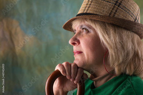 Model in a hat and jacket. Emotional look. Artistic background.