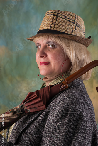 Model in a hat and jacket. Emotional look. Artistic background.