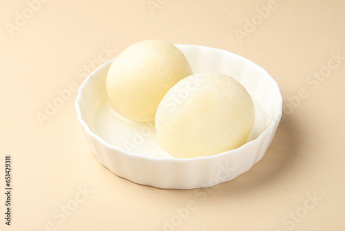 This dessert is called Rasgulla or Rosogolla, they are served in a bowl  photo
