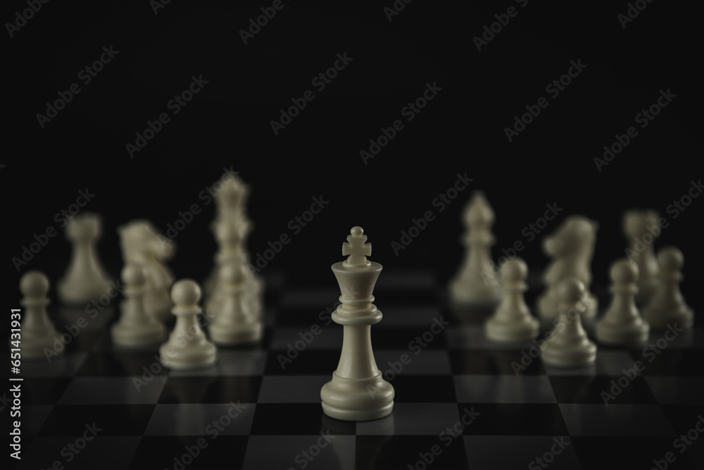 Pieces on chess board on black background for playing game and strategy.