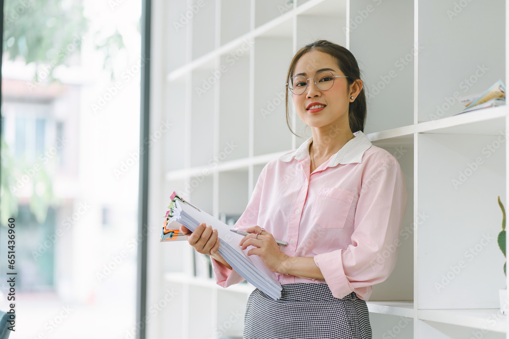 Portrait of beautiful asian secretary woman smiling while working in office. Portrait of beautiful asian secretary woman smiling while working in office.