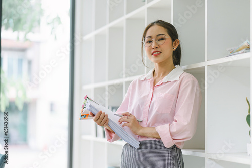 Portrait of beautiful asian secretary woman smiling while working in office.