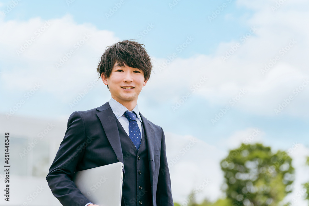 青空と若いスーツ姿のビジネスマン・新入社員・転職・就職活動
