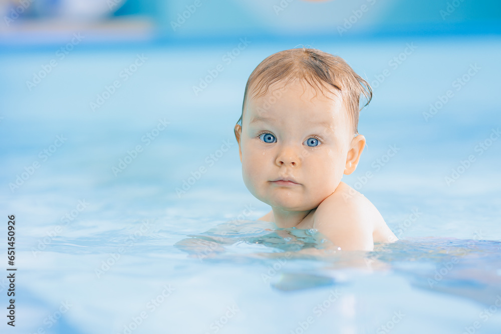 Teaching small swimmer happy baby girl in swimming pool. Concept healthcare sport for infant Teaching small swimmer happy baby girl in swimming pool. Concept healthcare sport for infant