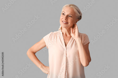 Mature woman on grey backgr...