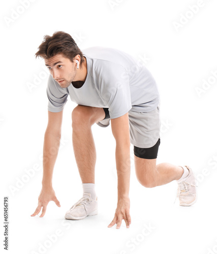 Sporty young man in starting position isolated on white background