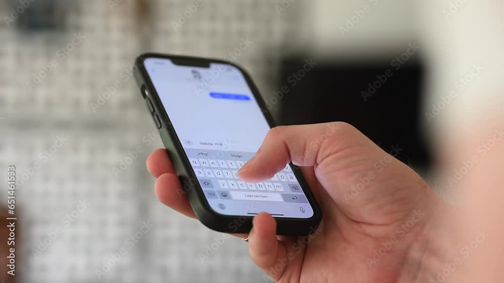 Close-Up: young adult man using cell phone to write messages. Hand hold mobile phone. 