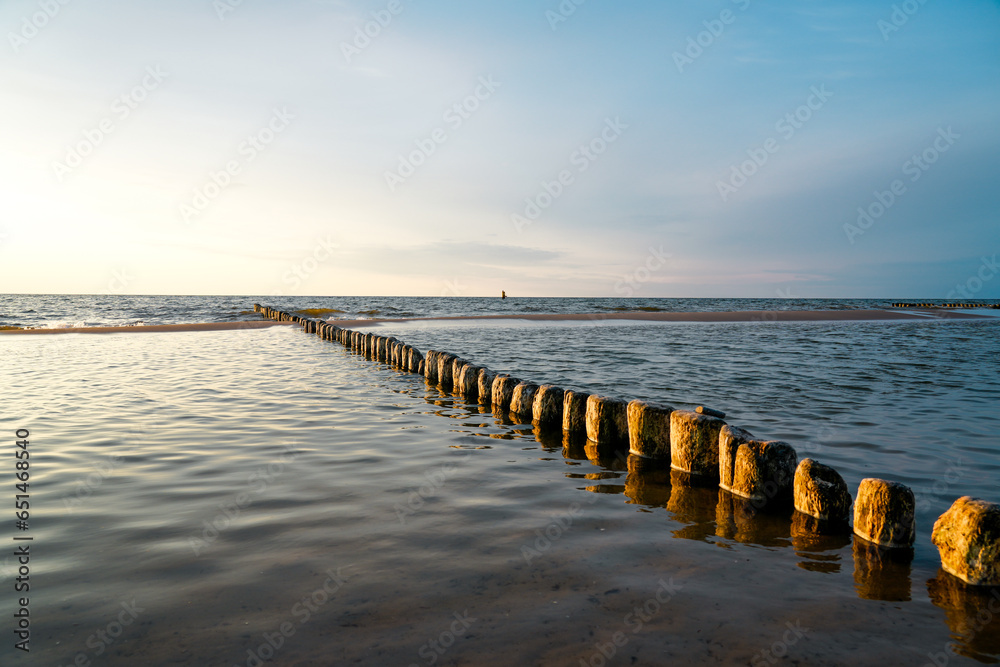 Obraz premium Sunset on the Baltic Sea in Poland. Landscape in the evening with setting sun by the sea.