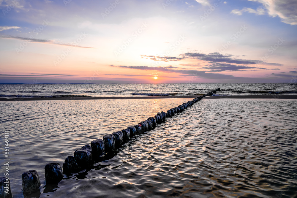 Obraz premium Sunset on the Baltic Sea in Poland. Landscape in the evening with setting sun by the sea.