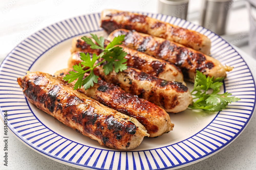 Plate of tasty grilled sausages on table