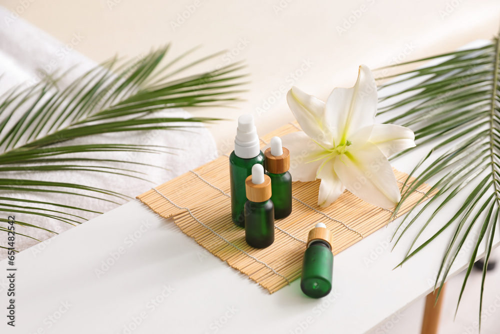 Spa composition with cosmetic dropper bottles on table in salon, closeup