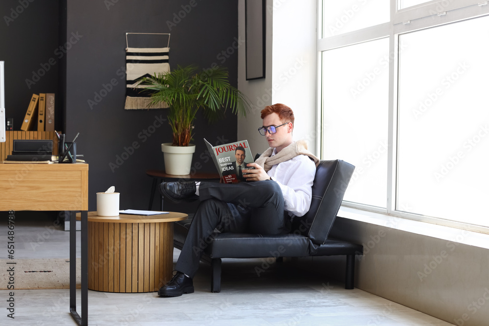 Young business owner reading magazine in office Young business owner reading magazine in office