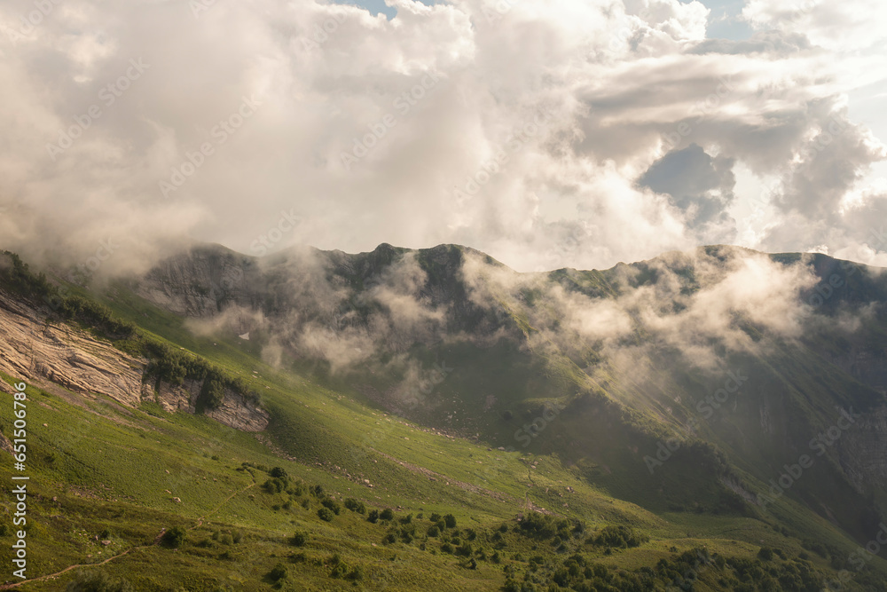 Thick clouds over the mountainside on a sunny summer day