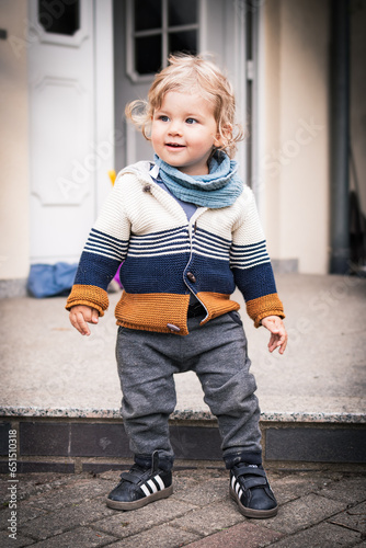 Baby steht von Terrasse auf und lächelt