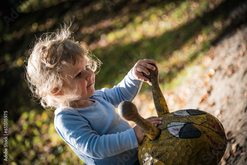 Baby wippt zum ersten Mal auf einer Holzschnecke