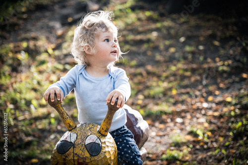 Baby wippt zum ersten Mal auf einer Holzschnecke