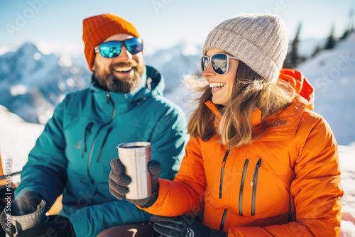 Happy young couple having fun and drinking hoot tea at ski resort , winter holiday concept