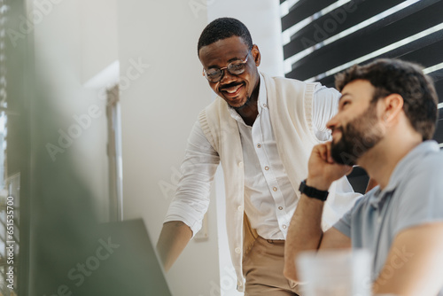 Multiracial business employee working together on a new project in modern office  discussing  having fun and smiling.