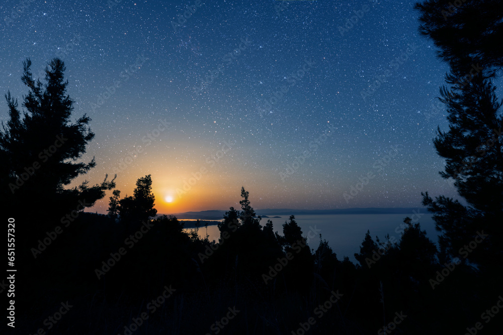 a night sea with a view of mountains and starry sky