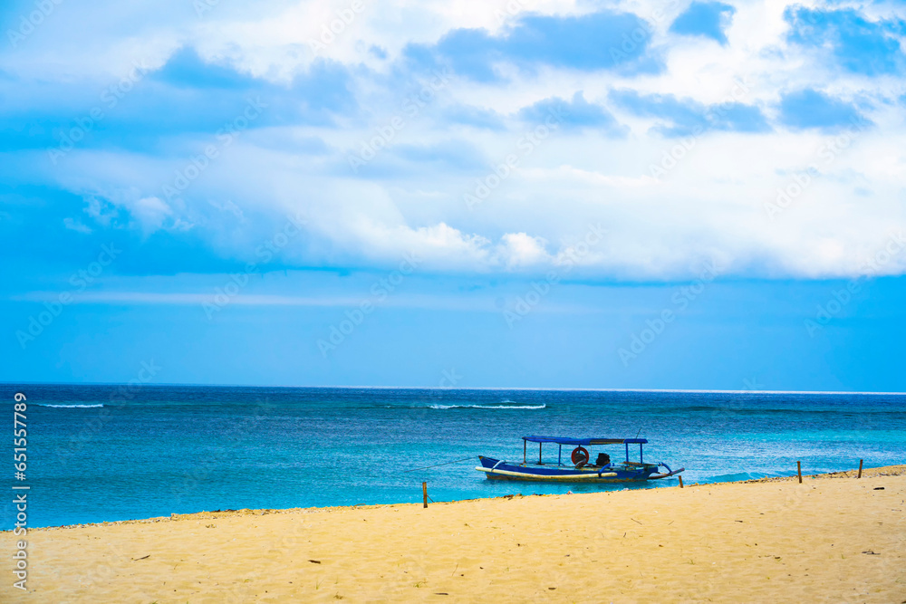 Tranquil beach scene in Tabuhan Island, Banyuwangi, with a moored traditional boat.
