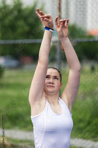 Girl playing basketball. Player throwing ball. Outdoor sports field in urban surroundings. © Nikola Spasenoski