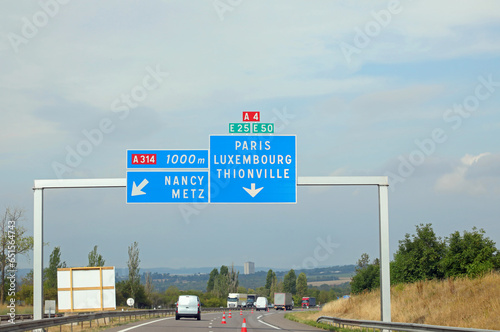 road sign on the road leading to Paris or Luxembourg and some car traffic