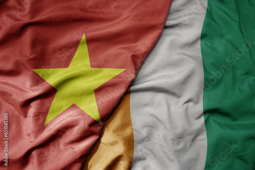 big waving realistic national colorful flag of vietnam and national flag of cote divoire . photo