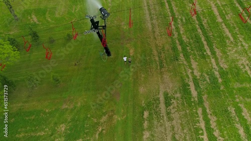 Aerial Forward Shot Of People Walking On Green Grass Below Ski Lift - Crawfordsville, Indiana photo