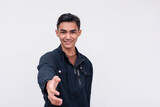 A good looking young Filipino man introducing himself to someone, offering a handshake. Isolated on a white background.