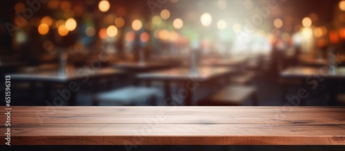 Wood table top with blurred restaurant background for displaying or assembling products © AkuAku