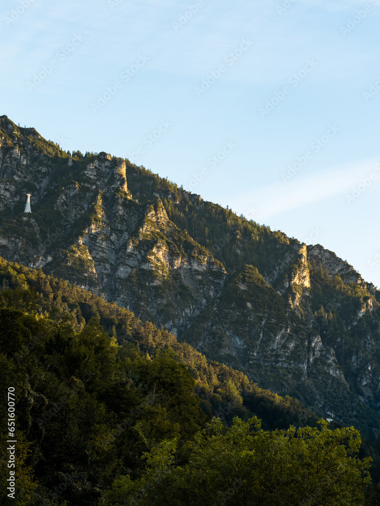 Steep mountain slope with trees and rocks. The sunset sunlight is shining on the beautiful nature in Germany. The Bavarian Alps are a travel destination within Europe.