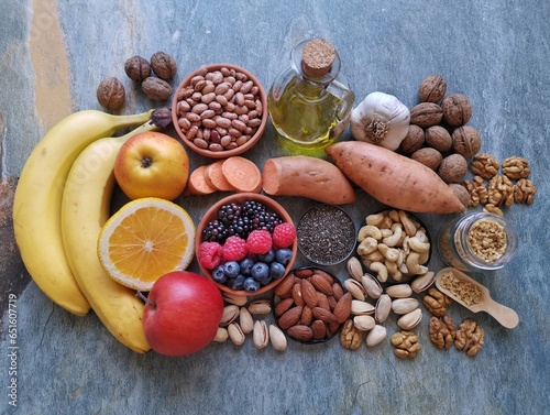 Foods to lower triglycerides or cholesterol. Healthy food products to reduce triglyceride levels and cholesterol. High triglycerides or bad cholesterol diet concept. Berries, nuts, apple, olive oil