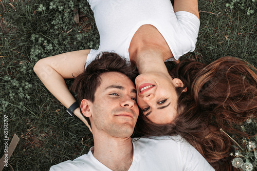 Top view of a young romantic couple lying in the grass