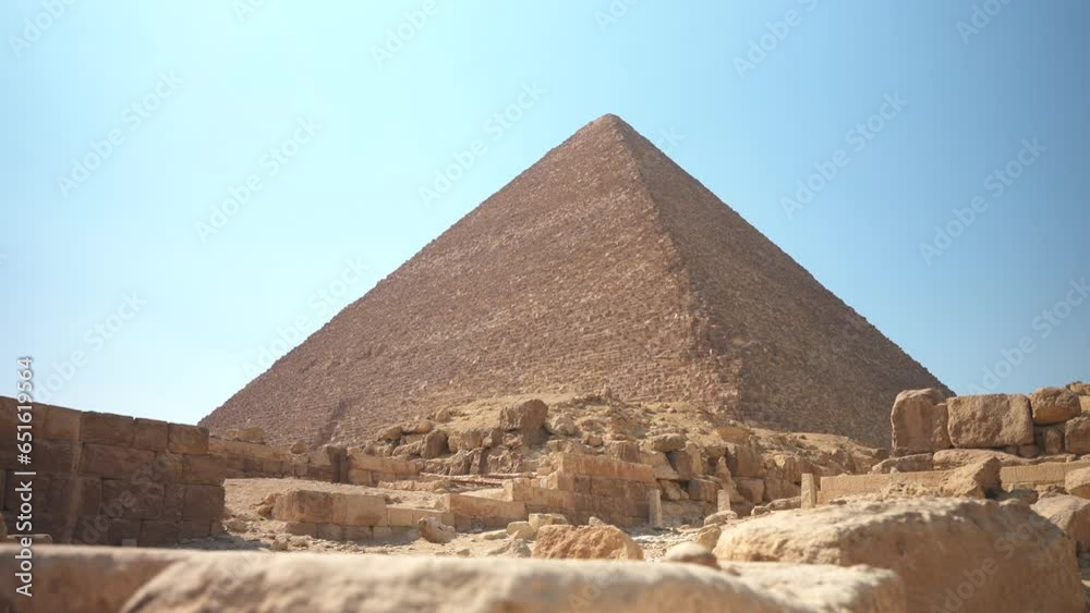 Slow motion low angle slide shot of The Great Pyramid of Khufu or Cheops in Giza. Birds flying in the foreground. Cairo, Egypt. Ancient mystical Wonders of the World Slow motion low angle slide shot of The Great Pyramid of Khufu or Cheops in Giza. Birds flying in the foreground. Cairo, Egypt. Ancient mystical Wonders of the World