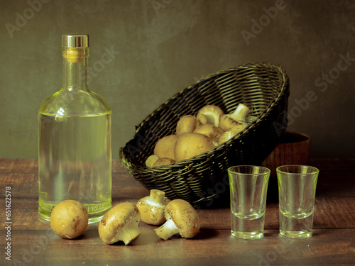 Antique-style still life with alcohol and mushrooms. photo