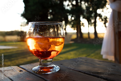 Cocktail glas with alkoholic drink color red. Reflecting sundown outside in a relaxing atmosphere.