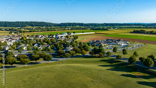 An Aerial View of a Rural Community, of Homes, in the Middle of Beautiful Farmlands, on a Sunny Summer Day