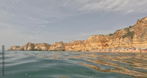 Drone video over Algarve cliffs near Praia do Marinha beach during daytime
