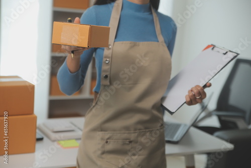 Business woman start up small business entrepreneur SME success .freelance woman working at home with Online Parcel delivery. SME and packaging deliveryconcept photo