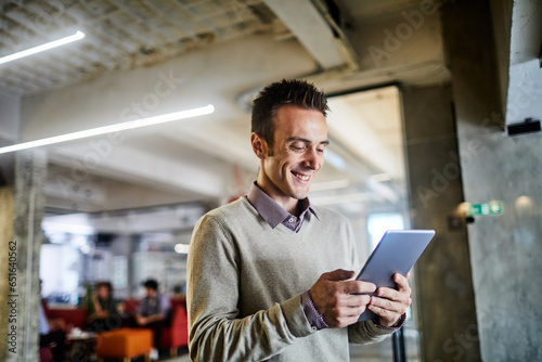 Young Caucasian man using a tablet in a modern business office