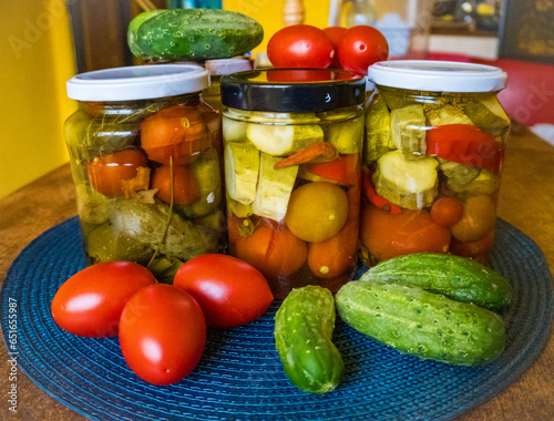 Glass jars with pickled cucumbers, pickles, pickled tomatoes and cabbage.