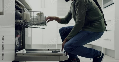 Hands, dishwasher and a man cleaning in his home for health, hygiene or to sanitize crockery and cutlery. Kitchen, appliance and dishes with a domestic person in an apartment for housework or chores