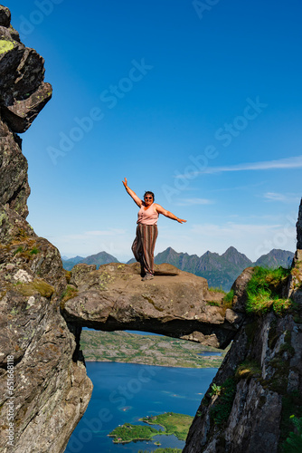 Active Senior tourist woman hiking at the beautiful Rock stuck in mountains Djevelporten. Norway. Happy pensioner climbing a mountain. Scandinavian tourism. Enjoying the outdoor leisure activity